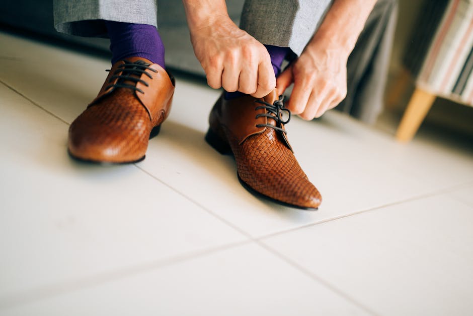 close up of man tying quality leather shoe