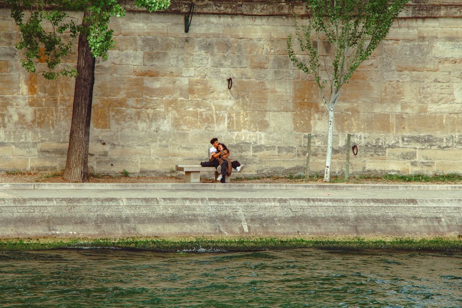 couple picnicking by river in French city