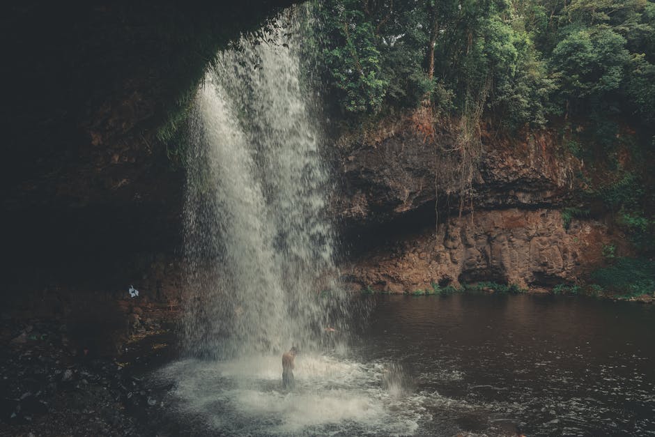 man hiking jungle waterfall