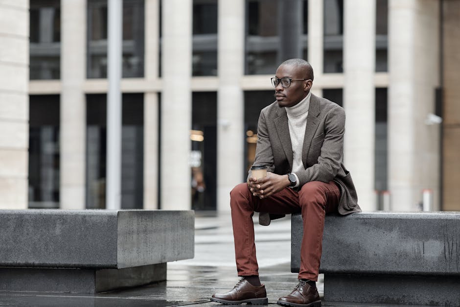 man holding coffee in modern casual outfit in urban setting