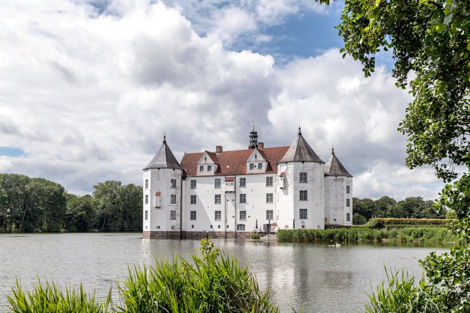 People cycling past a beautiful water castle in flat landscape