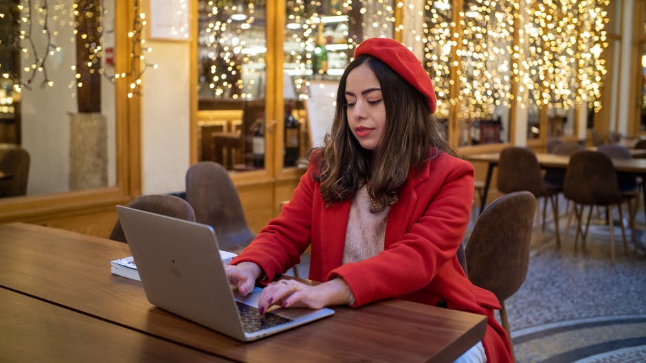 person working efficiently on laptop in cafe