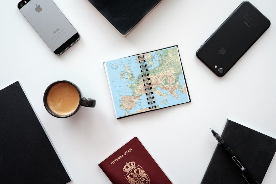 travel essentials like passport phone and map on a table