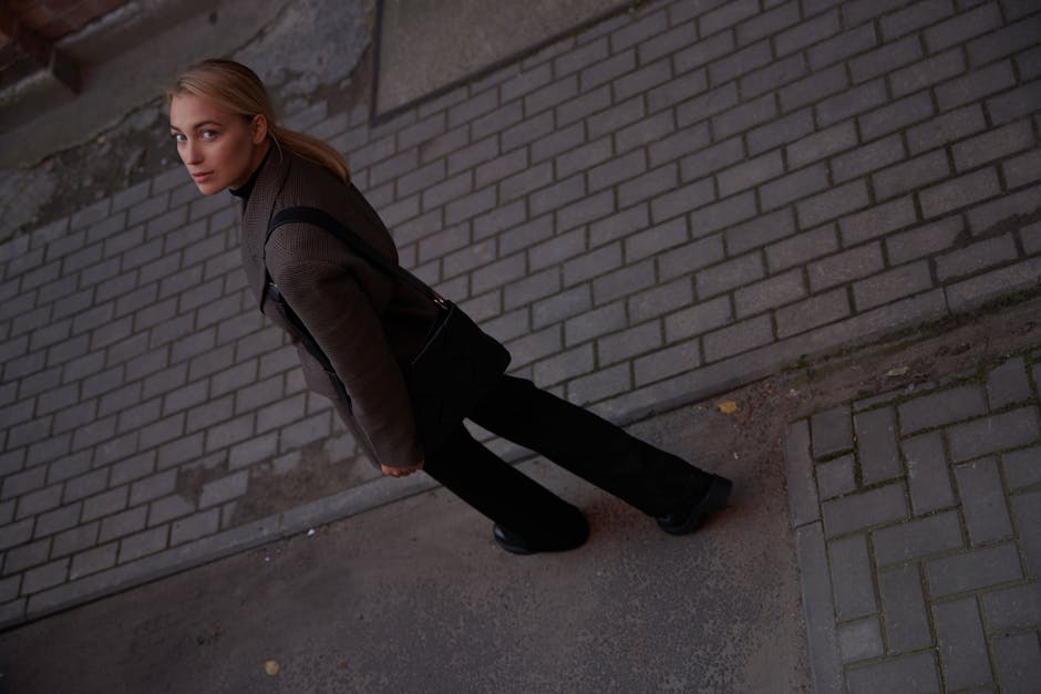 woman walking on city street wearing oversized blazer and wide leg pants