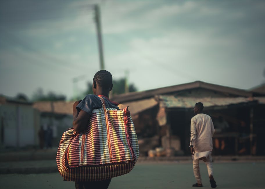 woman walking through a busy  street with colorful bags