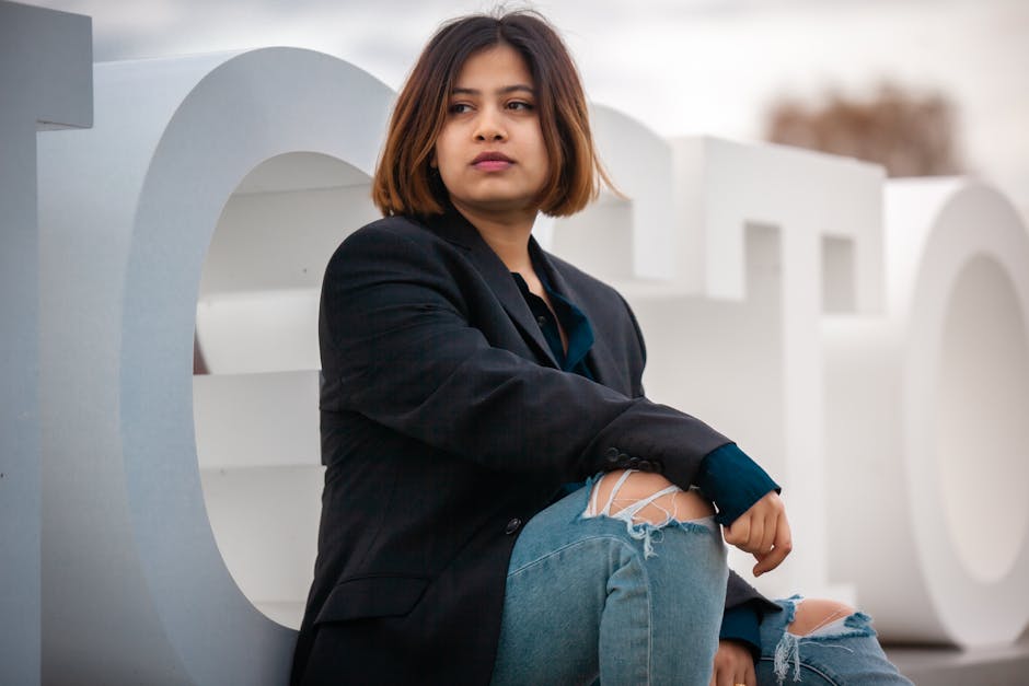 woman wearing a blazer and jeans looking confident