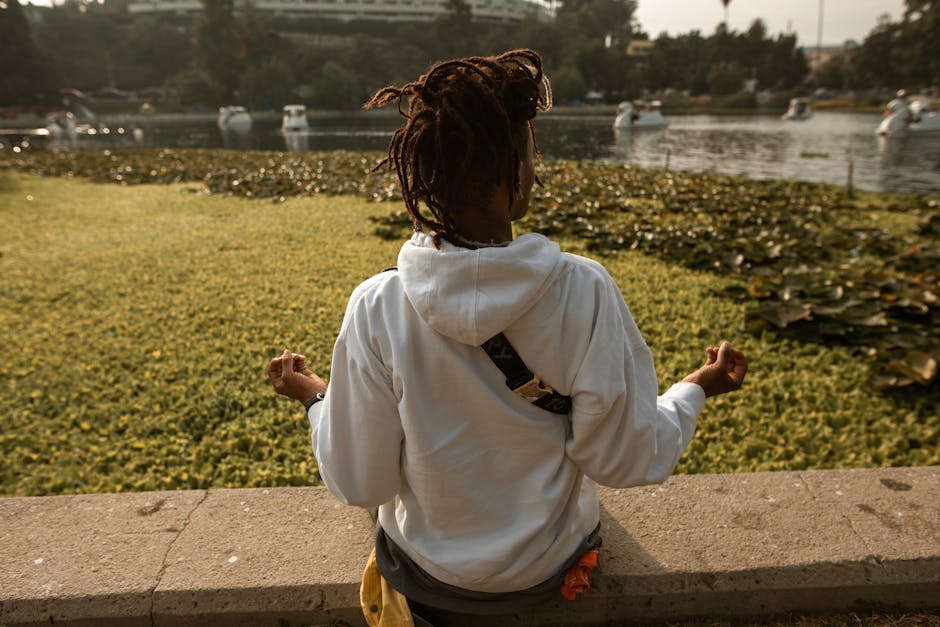 person meditating outdoors by lake