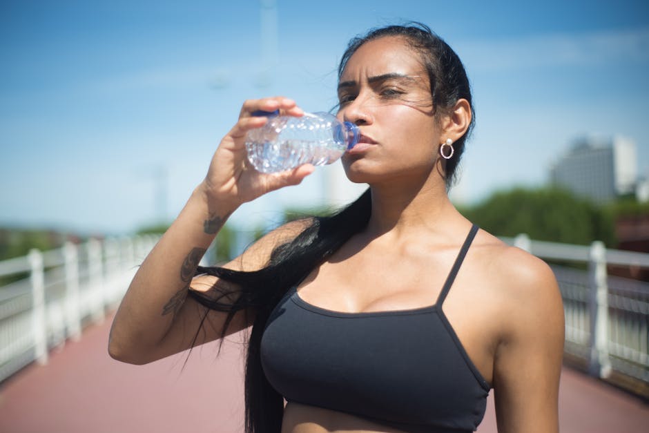 woman drinking water after workout