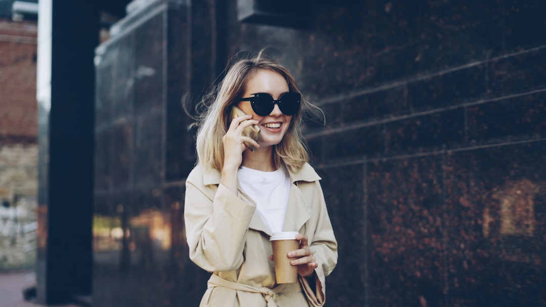 Woman in oversized coat drinking coffee outdoors