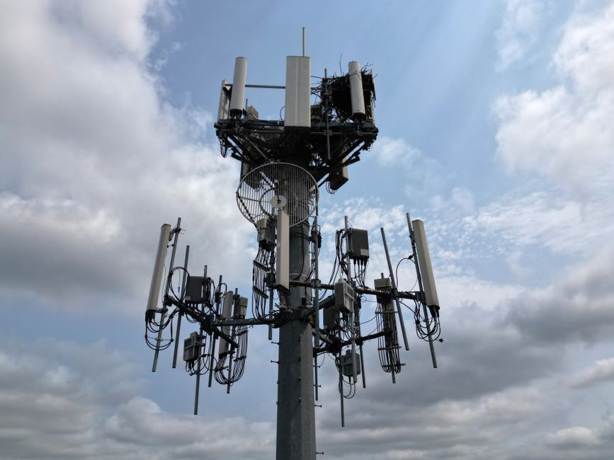 Un'antenna 5G su un tetto, con lo sfondo dello skyline di una città italiana, che simboleggia la copertura e la velocità delle nuove reti mobili.