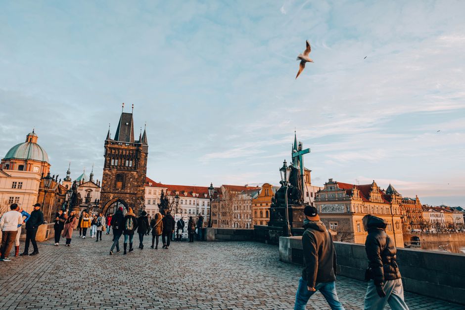 Una coppia passeggia lungo una storica strada di Praga al tramonto.