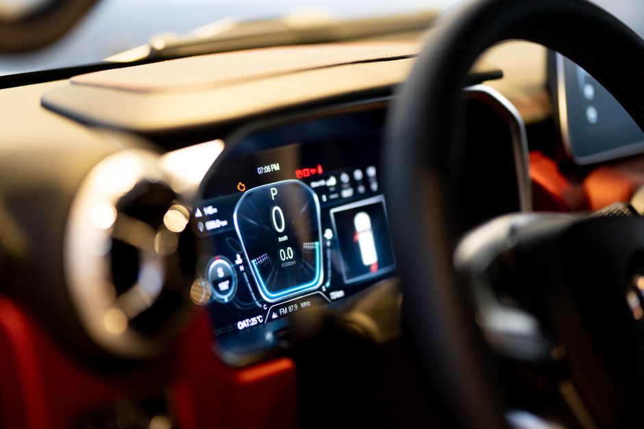 Dashboard di un'auto con un sistema di navigazione AI che mostra percorsi ottimizzati e dati sul traffico
