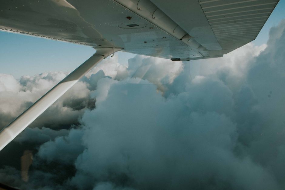 Вид з вікна літака на хмари та крило літака під час польоту