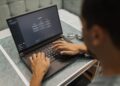 Бізнесмен працює за ноутбуком, на екрані видно інтерфейс чат-бота ШІ, що демонструє взаємодію з робочими запитами.