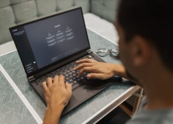 Бізнесмен працює за ноутбуком, на екрані видно інтерфейс чат-бота ШІ, що демонструє взаємодію з робочими запитами.
