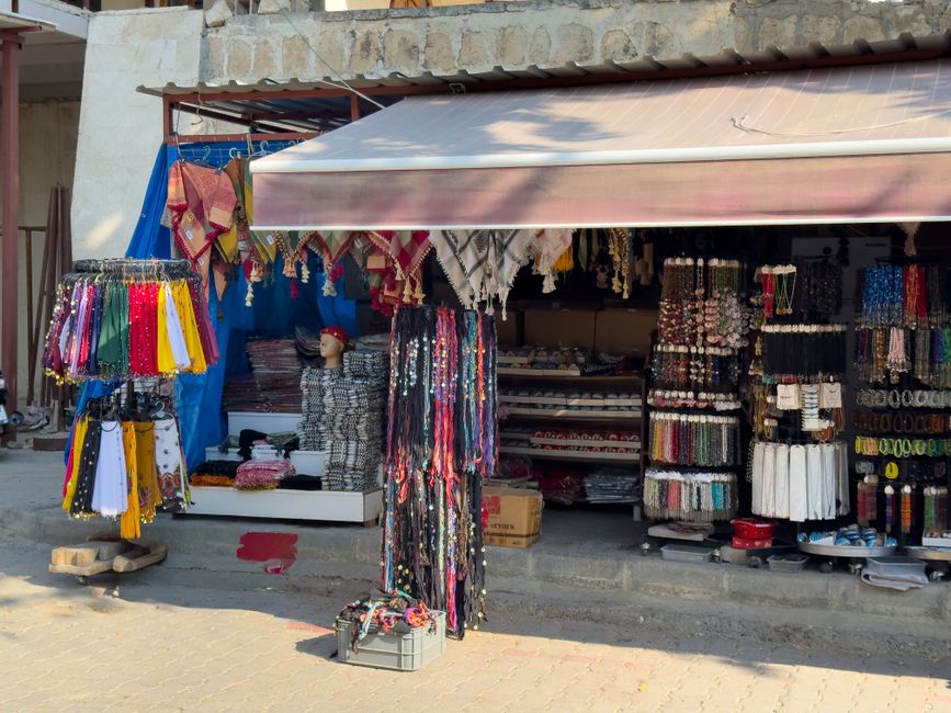 Una collezione di sciarpe di seta colorate e cinture elegantemente appese, pronte per essere abbinate a diversi outfit.
