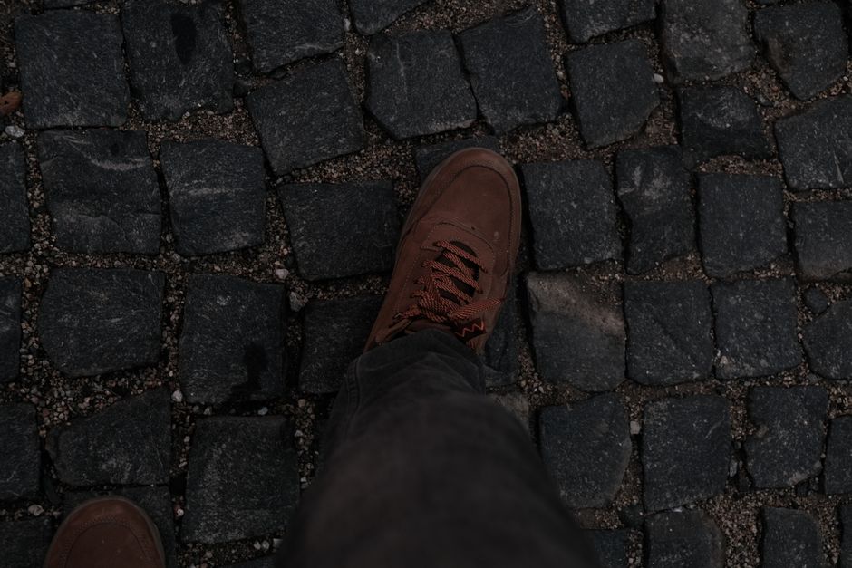 Scarpe comode per camminare adagiate su un'antica strada acciottolata in Italia, pronte per l'esplorazione urbana