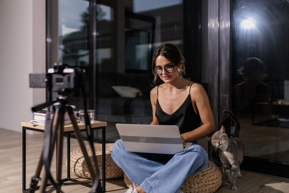 Un content creator concentrato, con cuffie, lavora al computer, utilizzando strumenti IA in modo consapevole per la creazione di contenuti, bilanciando creatività umana e assistenza tecnologica.
