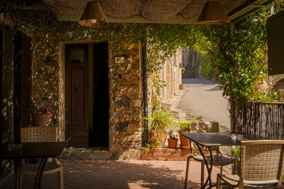 Coppia cena tranquilla in un caffè all'aperto in un borgo italiano, rispettando le usanze locali.