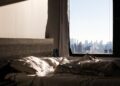 Una donna serena si gode un momento di pace in un appartamento cittadino illuminato dalla luce del mattino.