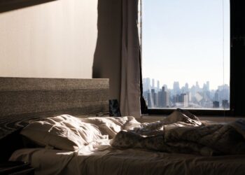 Una donna serena si gode un momento di pace in un appartamento cittadino illuminato dalla luce del mattino.