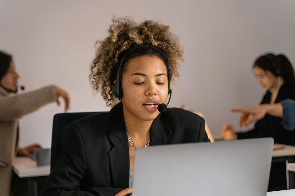 Un agente del servizio clienti con cuffie e laptop, simbolo di supporto e assistenza di qualità per gli operatori di telefonia mobile.
