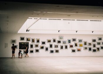 Famiglia esausta seduta in un museo affollato, bambini annoiati
