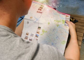 Famiglia che esamina una mappa della città, scegliendo la migliore area hotel