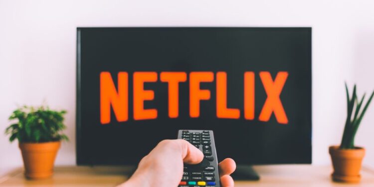 Una famiglia che guarda un film in streaming sul divano, con lo smartphone di un genitore che funge da hotspot, a significare un alto consumo di dati.
