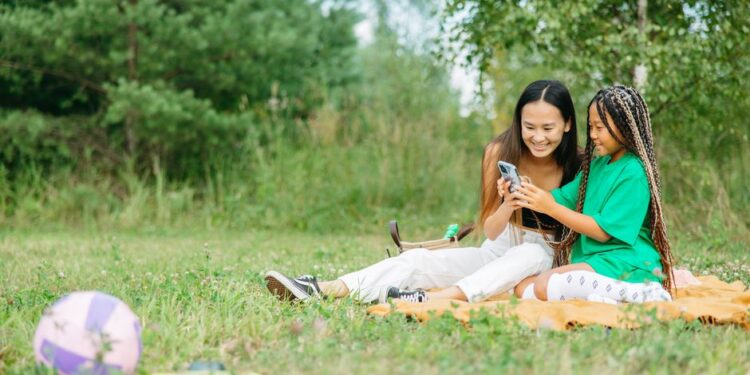 Famiglia che usa l'hotspot mobile all'aperto con laptop e tablet