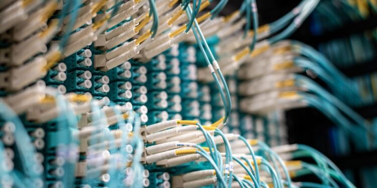 Cavi di fibra ottica e apparecchiature di rete, che rappresentano le complesse infrastrutture di telecomunicazione.