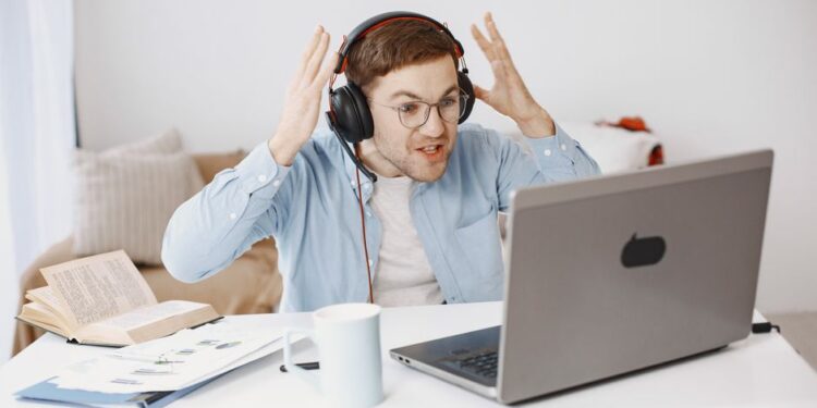 Un uomo frustrato con il laptop che mostra un caricamento lento del Wi-Fi in un ambiente domestico.