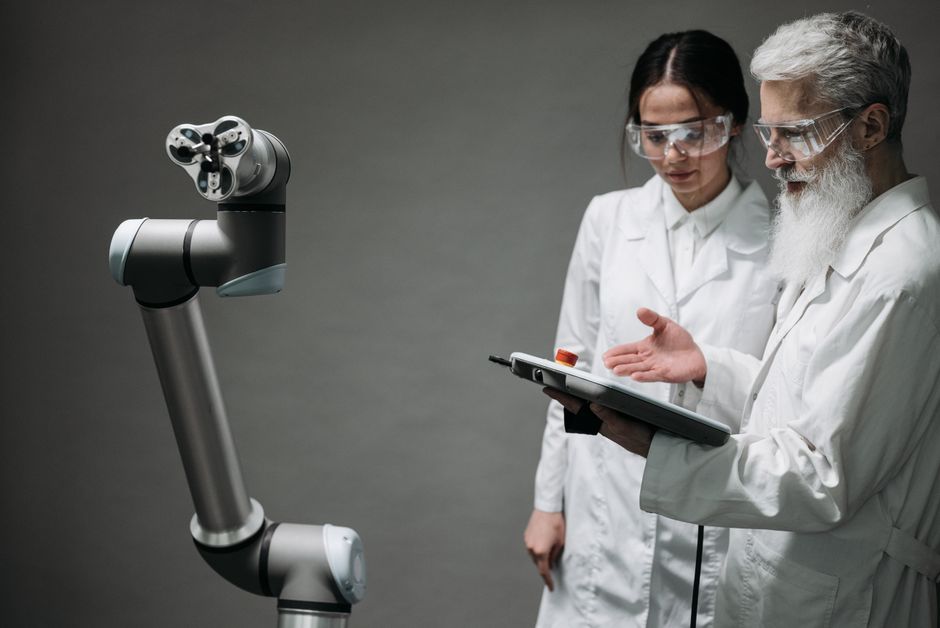 Un uomo e un robot che lavorano insieme, visualizzando un'interfaccia complessa. L'immagine simboleggia la collaborazione tra l'intelligenza umana e quella artificiale nell'elaborazione di dati.