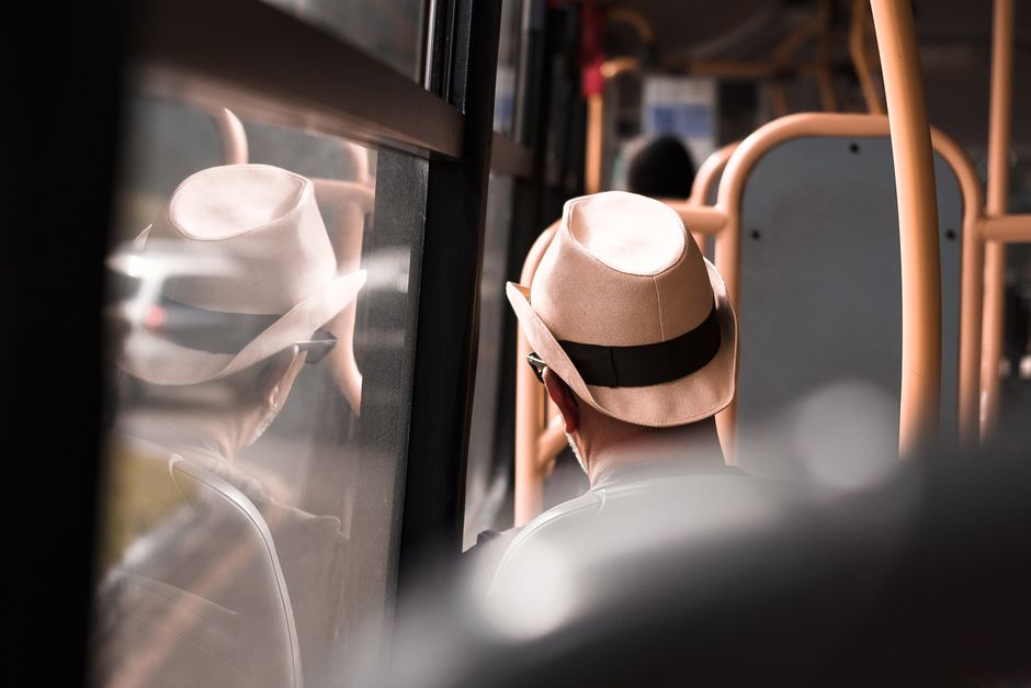 Una persona seduta comodamente su un autobus, osservando il panorama attraverso il finestrino, con l'idea di un viaggio economico e panoramico attraverso l'Europa o l'Italia.