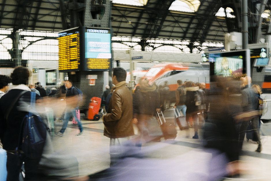 Viaggiatori che salgono su un treno ad alta velocità in una stazione europea, mostrando un mezzo di trasporto efficiente per i tour multi-città.