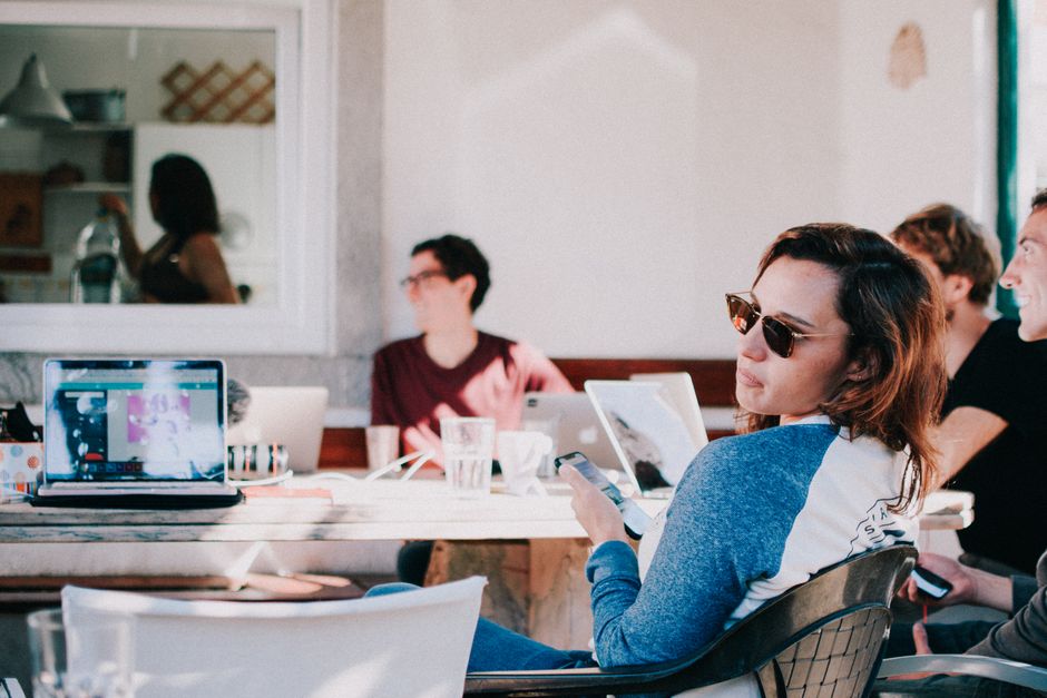 Diverse persone che lavorano da remoto all'aperto con laptop e smartphone, mostrando la necessità di una connessione mobile affidabile.