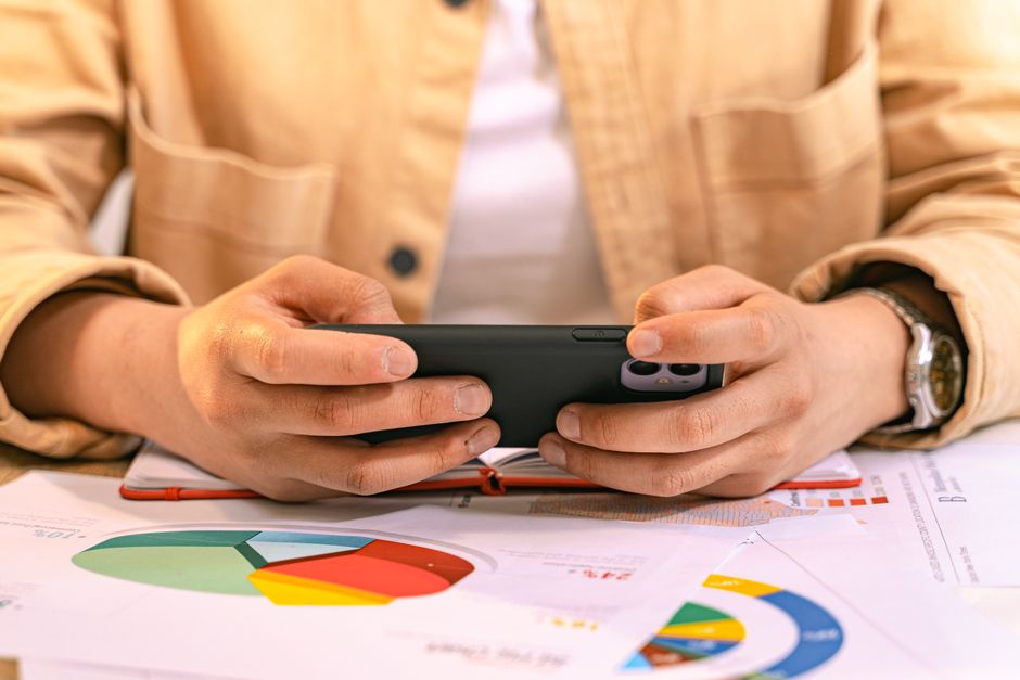 Mano che tiene uno smartphone e naviga tra le impostazioni per ottimizzare il consumo di dati.