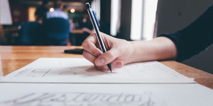 Un imprenditore in Italia mostra frustrazione mentre tenta di scrivere istruzioni chiare al suo computer, simboleggiando la difficoltà di formulare prompt per il lavoro efficaci.