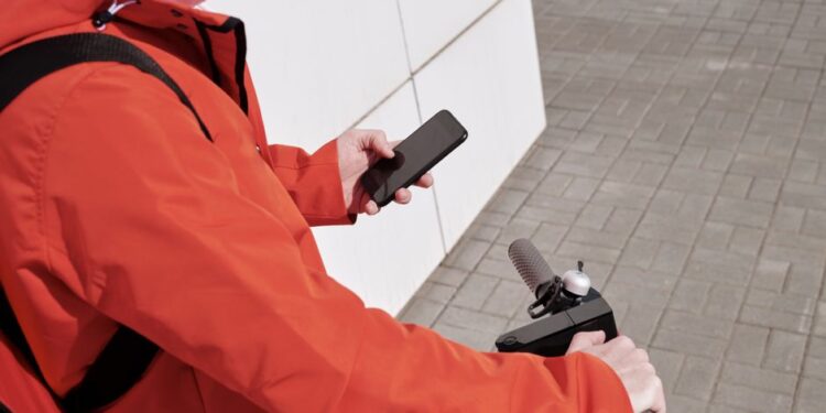 Persona che controlla l'app del trasporto pubblico su smartphone in una stazione della metropolitana