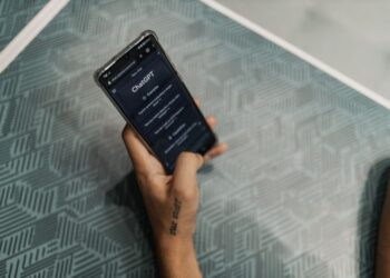 Чалавек карыстаецца смартфонам з AI-памочнікам, які адлюстроўвае прагноз надвор'я і маршрут.