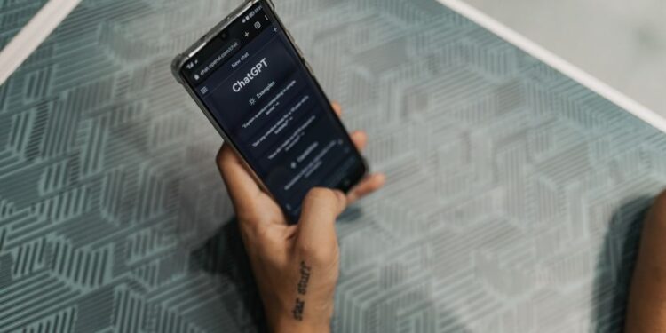 Чалавек карыстаецца смартфонам з AI-памочнікам, які адлюстроўвае прагноз надвор'я і маршрут.