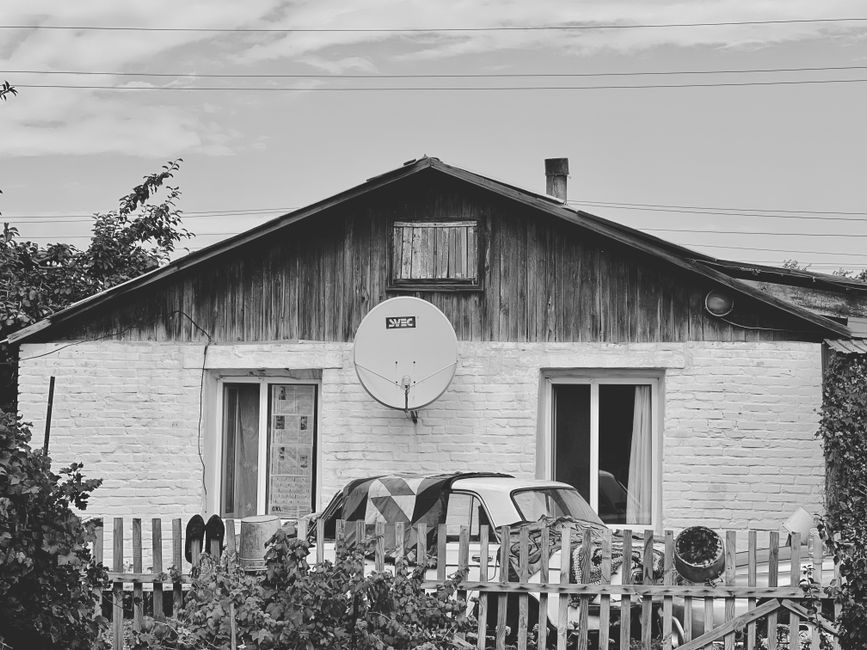 Parabola satellitare installata sul tetto di una casa isolata in campagna con montagne sullo sfondo