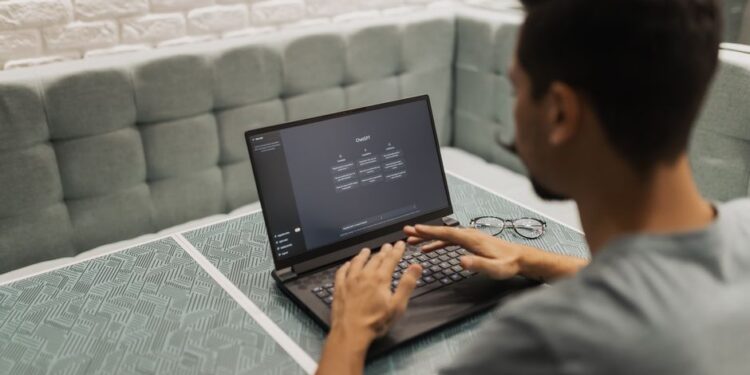 Un imprenditore di una piccola impresa italiana esamina il testo tradotto dall'AI sul suo laptop, con grafici e dati sullo schermo.