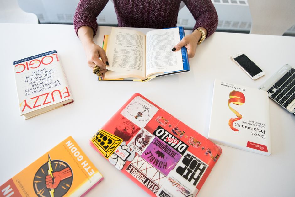 Studente universitario che confronta diverse offerte di operatori telefonici su un laptop, con libri sullo sfondo.