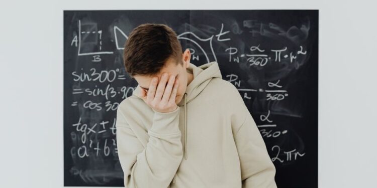 Uno studente frustrato guarda uno schermo con il simbolo del buffering, evidenziando il problema della bassa velocità internet per streaming e studio.
