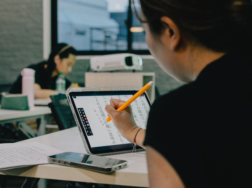 Student s notebookem a knihami, který používá AI aplikaci k organizaci studijního plánu, se zaměřením na efektivitu.