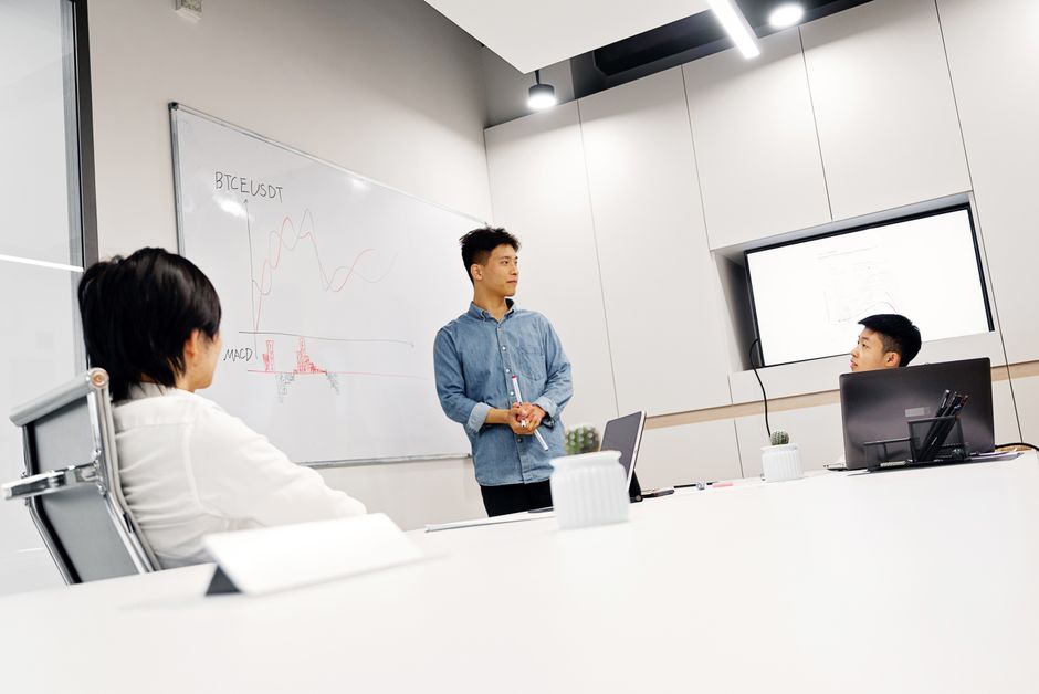 Un gruppo di colleghi di una PMI italiana discute le politiche di sicurezza e la privacy dei dati in relazione all'uso degli strumenti AI in un moderno ufficio.