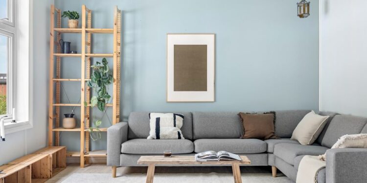 Un soggiorno in un appartamento pulito e minimalista con luce naturale che entra dalle finestre, mobili ordinati e piante sparse che creano un ambiente sereno e accogliente.