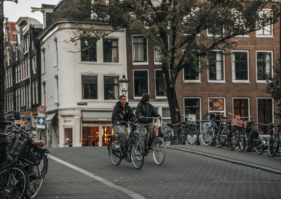 Turista in bicicletta su una pista ciclabile alberata in una città europea