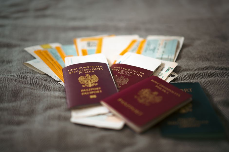 Uno zaino da viaggio e un passaporto posati su un letto d'albergo, a indicare la preparazione per un viaggio leggero e confortevole.